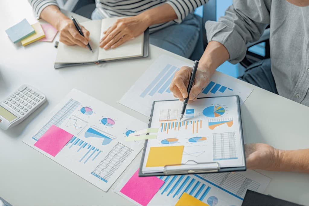 People reviewing charts and documents at a desk