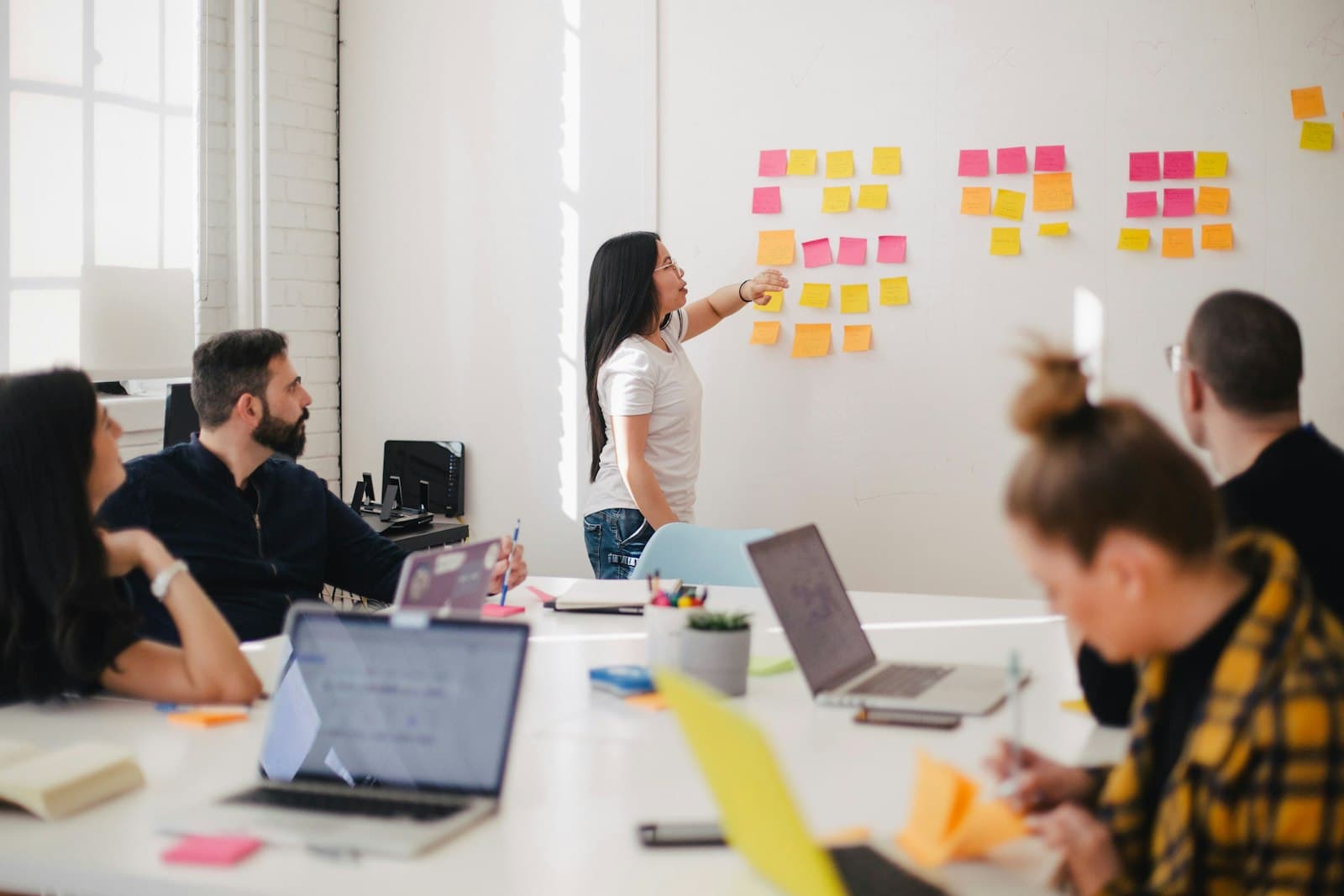 Facilitator running a workshop with sticky notes on a board